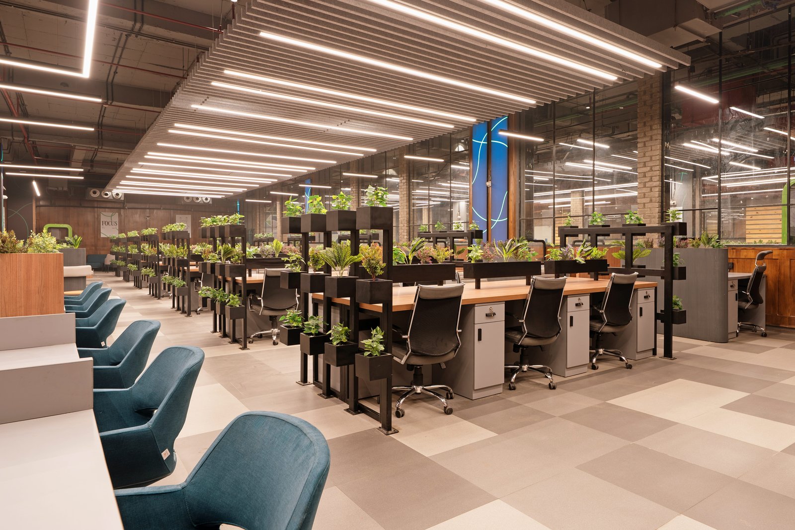 Professionals working on laptops in a modern coworking lounge area.
